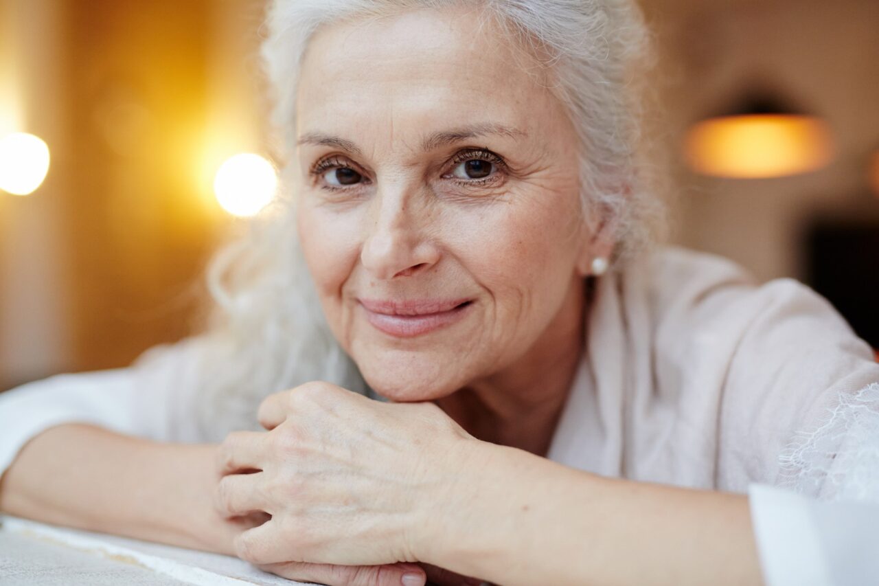 mulher de cabelo branco sorrindo para ilustrar pauta sobre como cuidar dos cabelos grisalhos