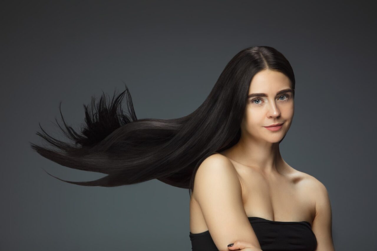 mulher com longos cabelos pretos para ilustrar texto de como fazer o cabelo crescer rápido e forte