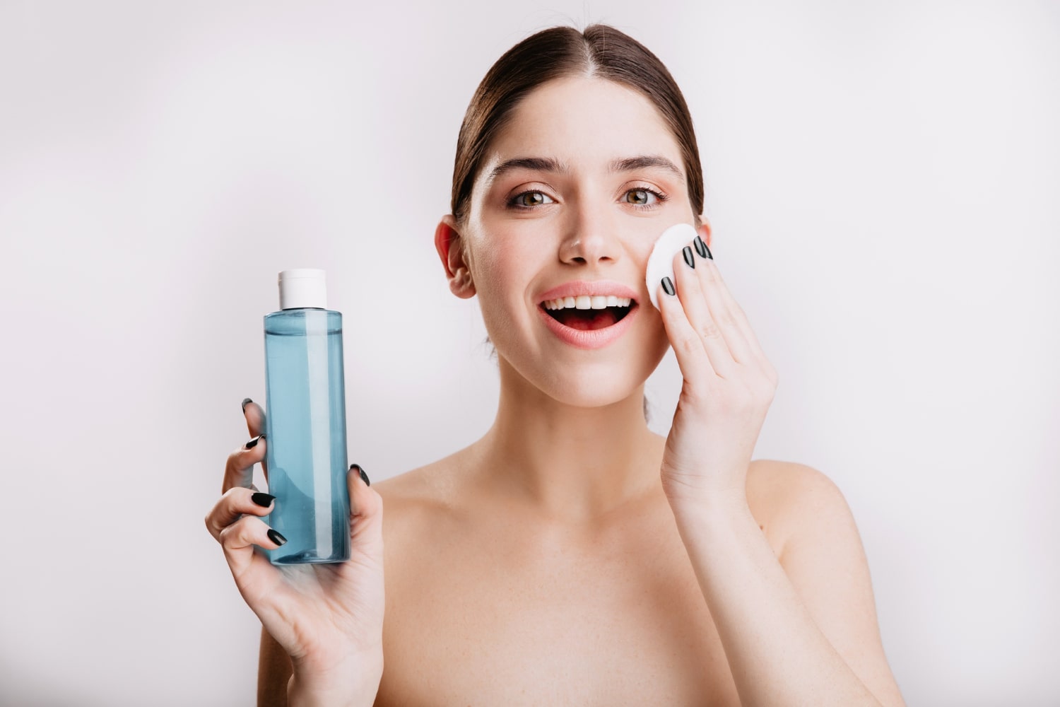 mulher passando produto no rosto para ilustrar texto sobre como preparar a pele para maquiagem