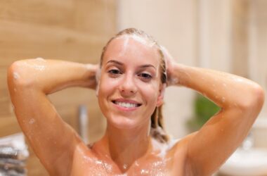 mulher com cabelo molhado no banho para ilustrar texto sobre Oo que acontece se dormir com cabelo molhado